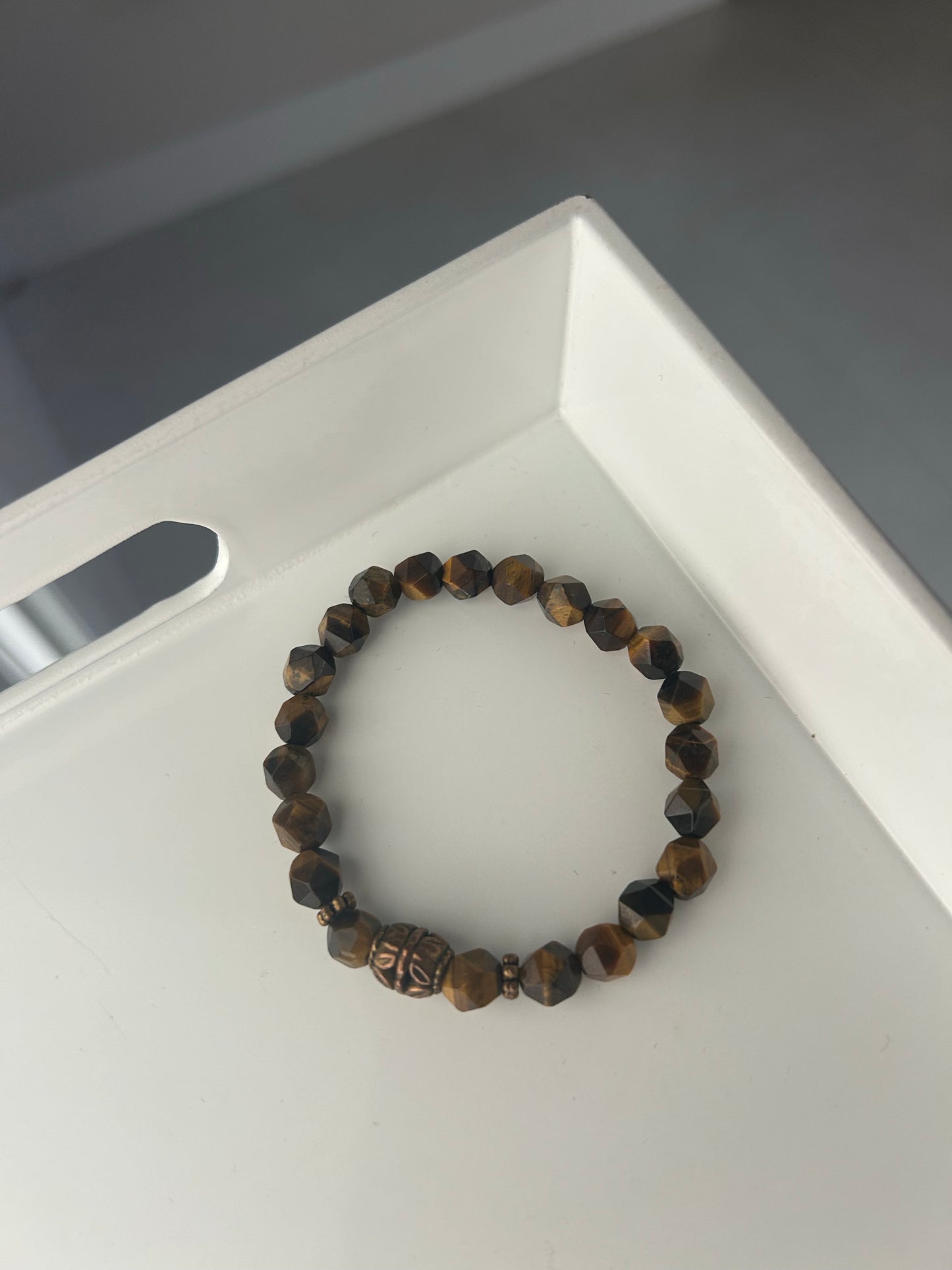 Beaded bracelet on a white tray with a gray background