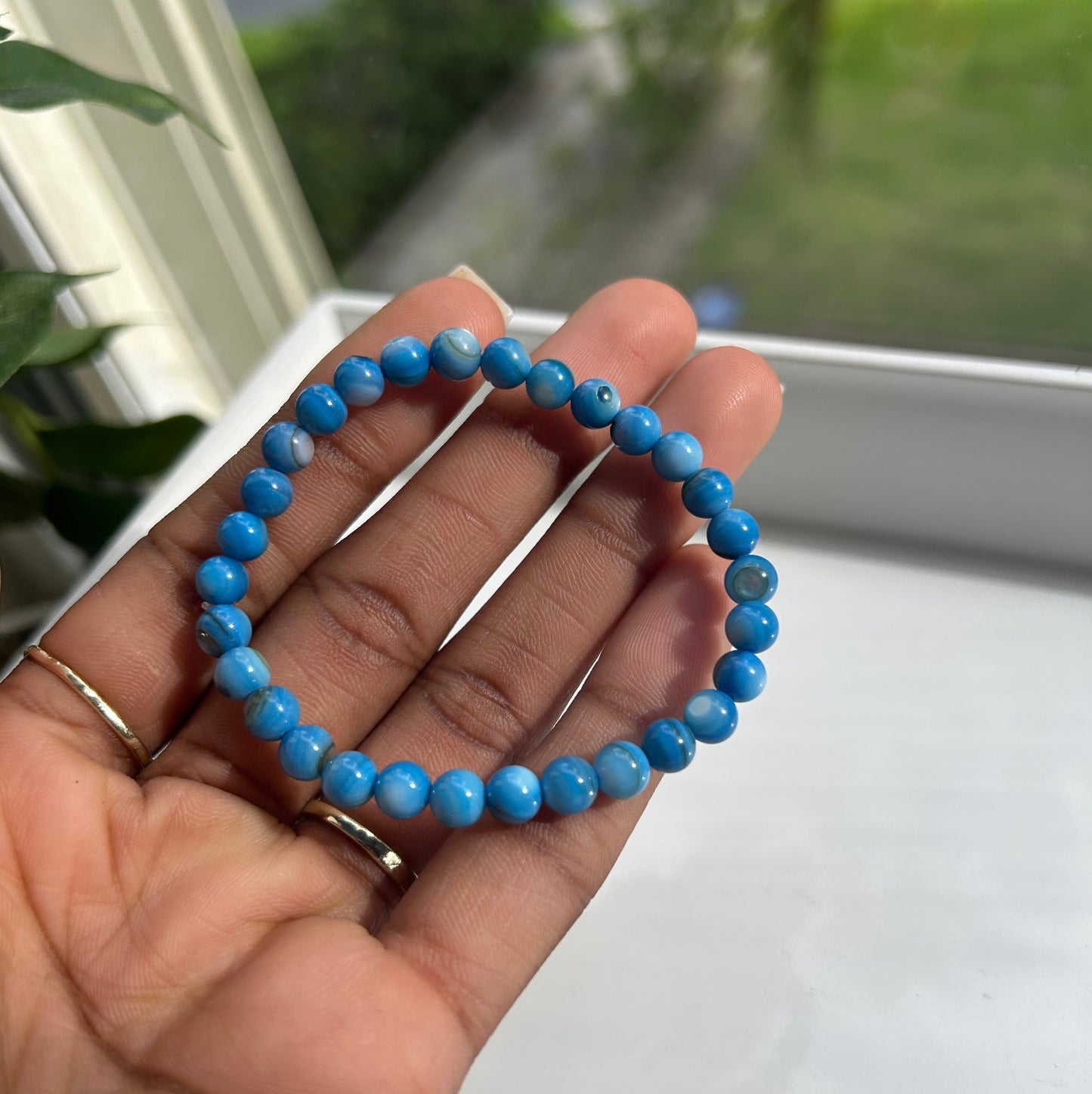 Blue shell, brown bead, bracelets, white background, natural background