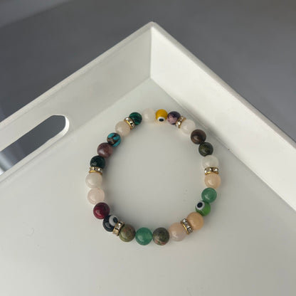 Multicolored beaded bracelet on a white surface with a gray background