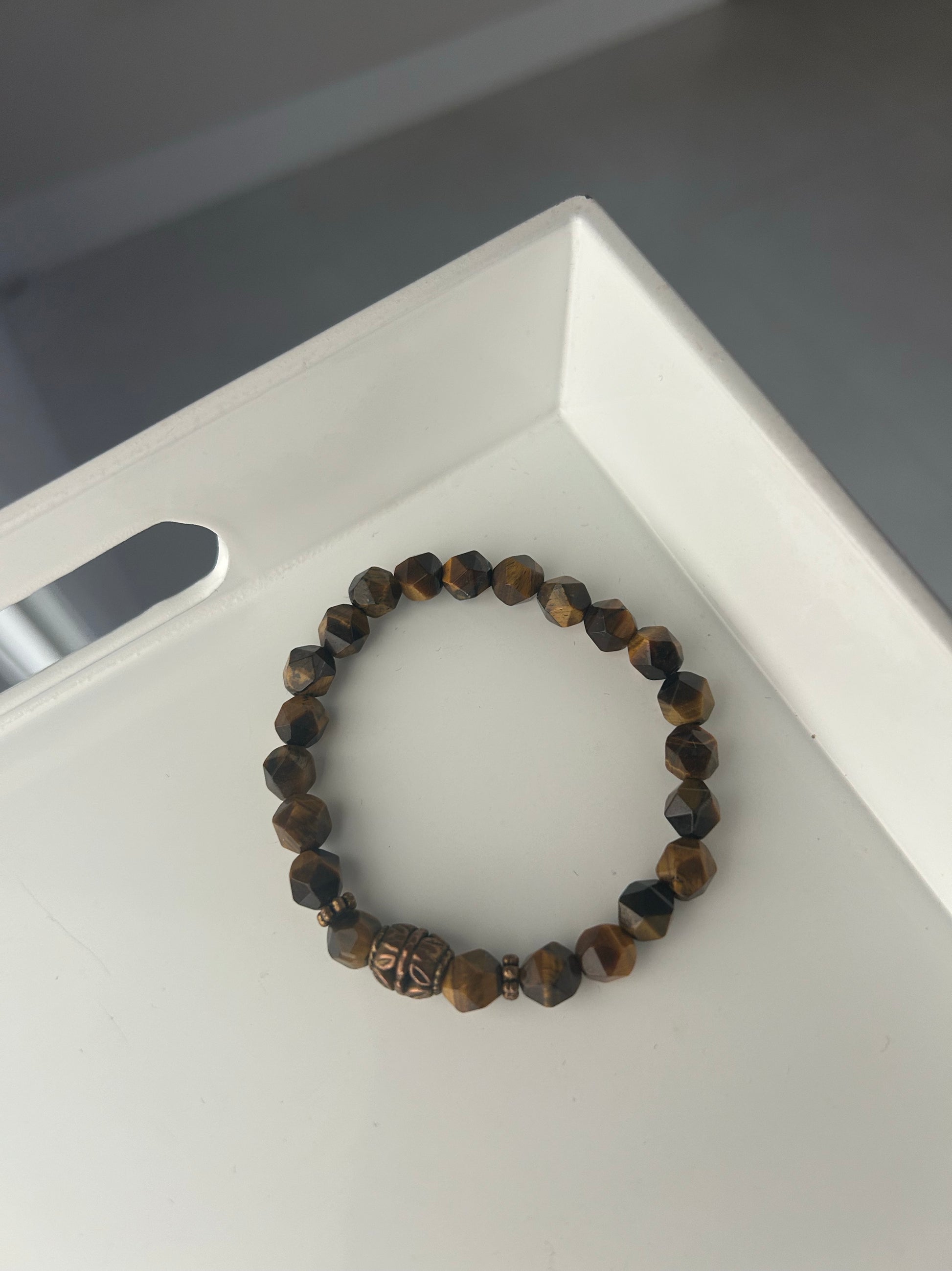 Beaded bracelet on a white tray with a gray background