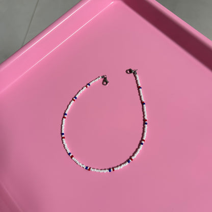 Beaded necklace on a pink surface