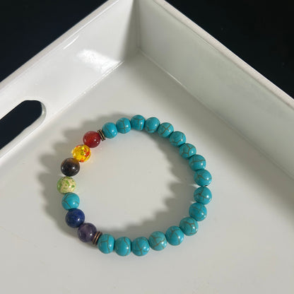 Turquoise beaded bracelet with multicolored beads on a white surface