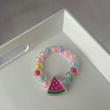 Children Colorful beaded bracelet with a watermelon charm on a white surface