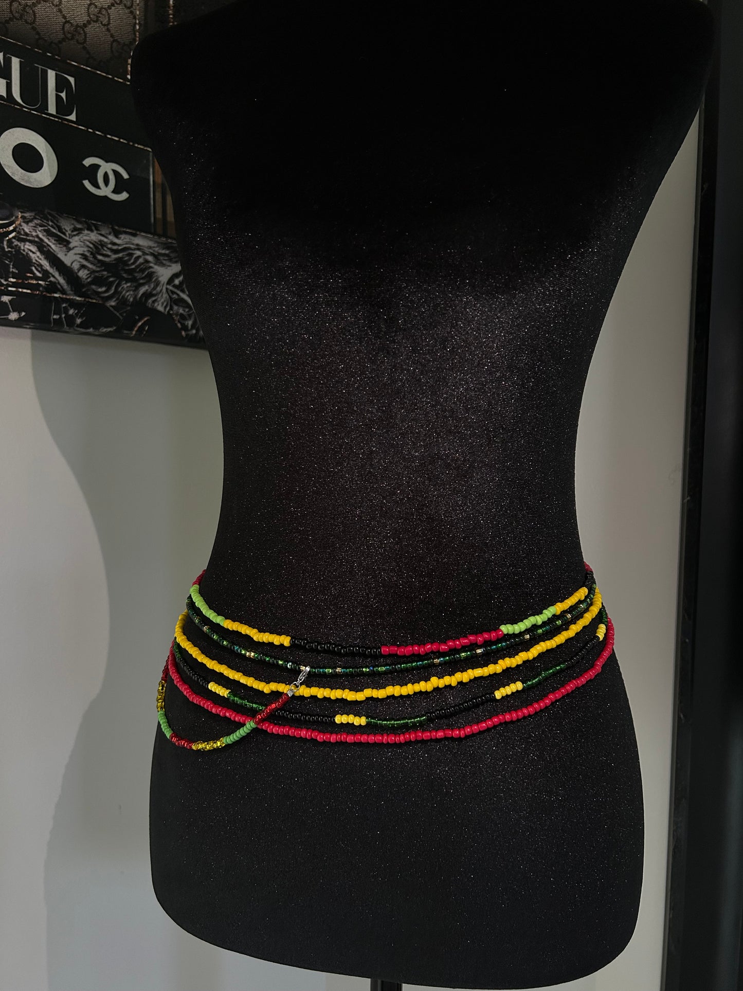 Black bow tie with colorful trim on a mannequin head, with a visible brand logo in the background.
