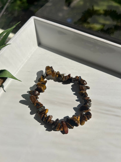 Tiger's eye chip bracelet on a white surface with a blurred background