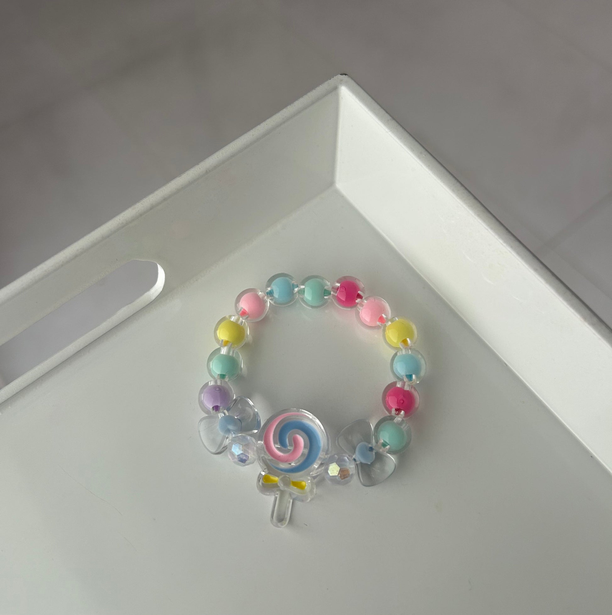 Children Colorful beaded bracelet with a spiral charm on a white surface