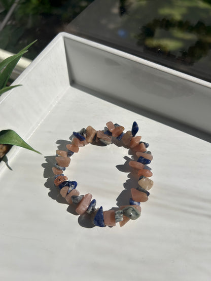 Multicolored stone bracelet on a white surface with a blurred background
