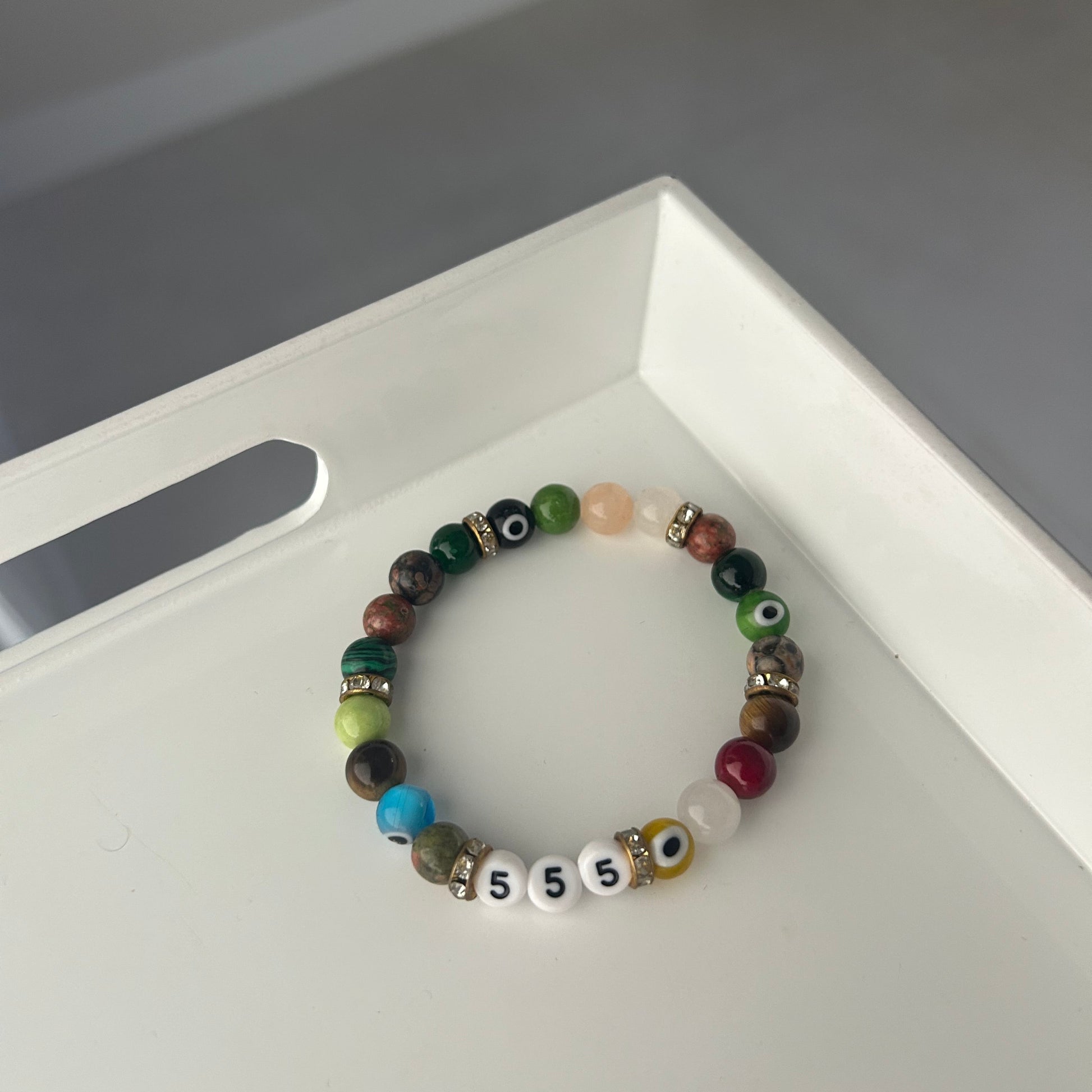 Multicolored beaded bracelet on a white surface with a blurred background