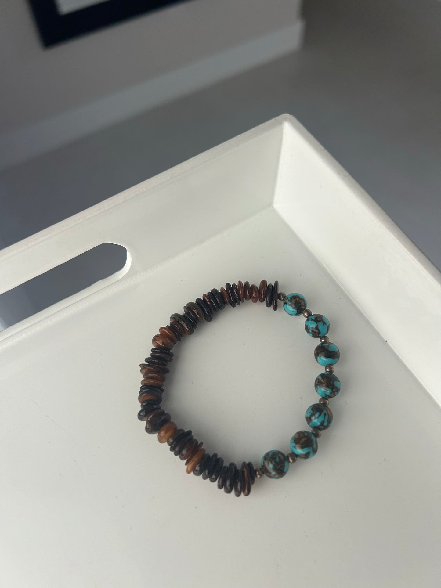 Beaded bracelet on a white surface with a blurred background