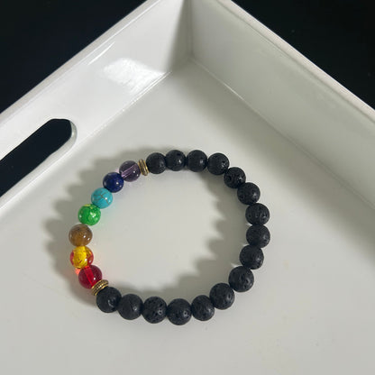 Black beaded bracelet with rainbow-colored beads on a white tray