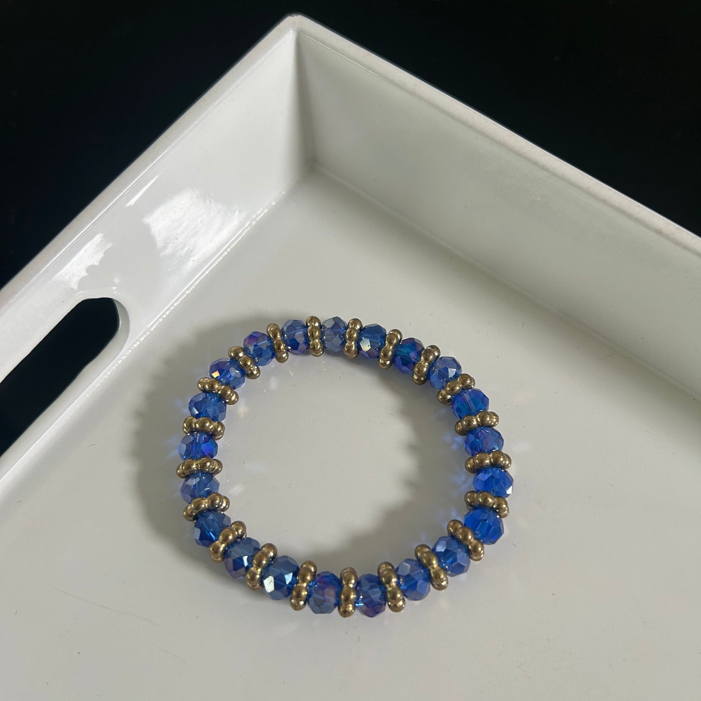 Blue beaded bracelet on a white tray