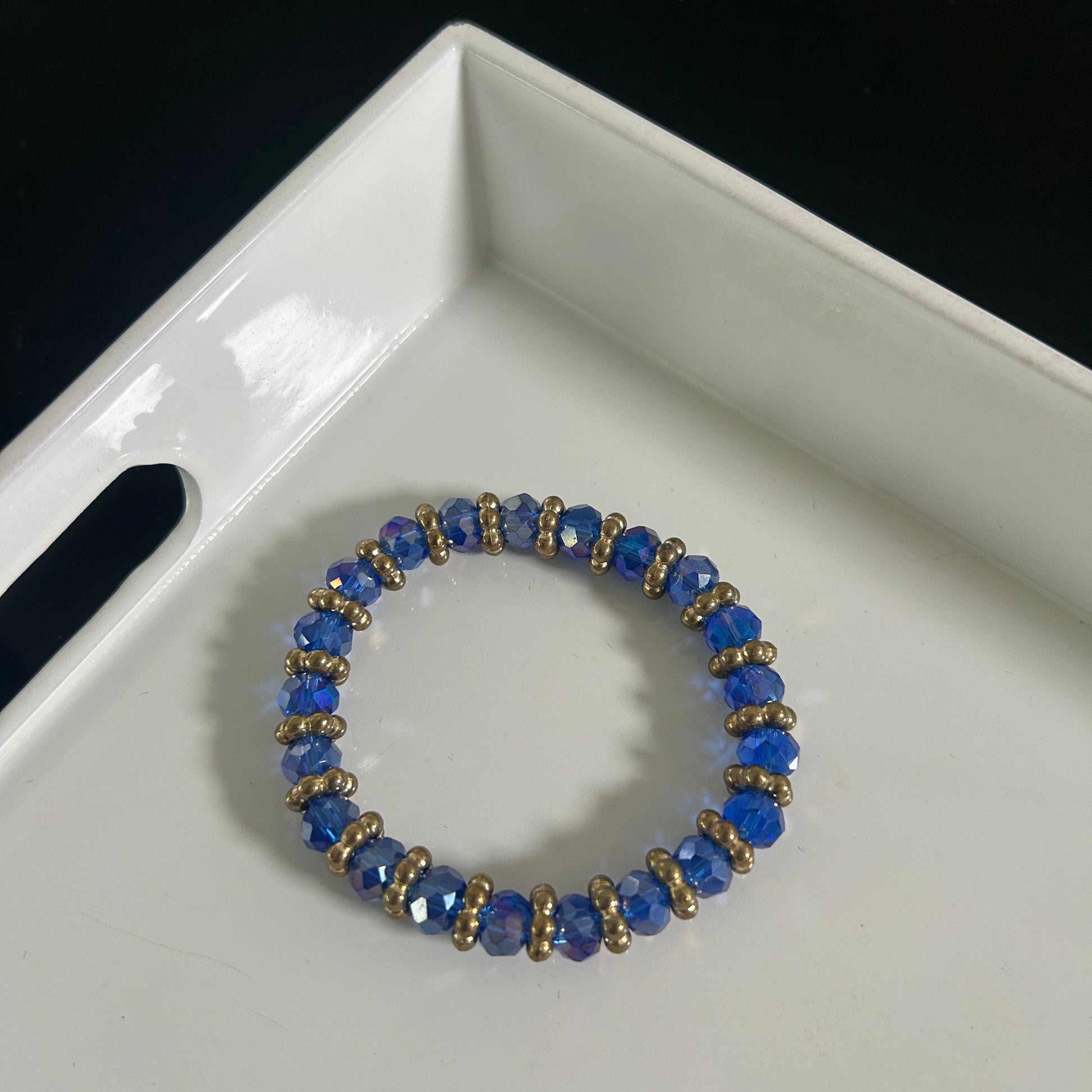 Blue beaded bracelet on a white tray