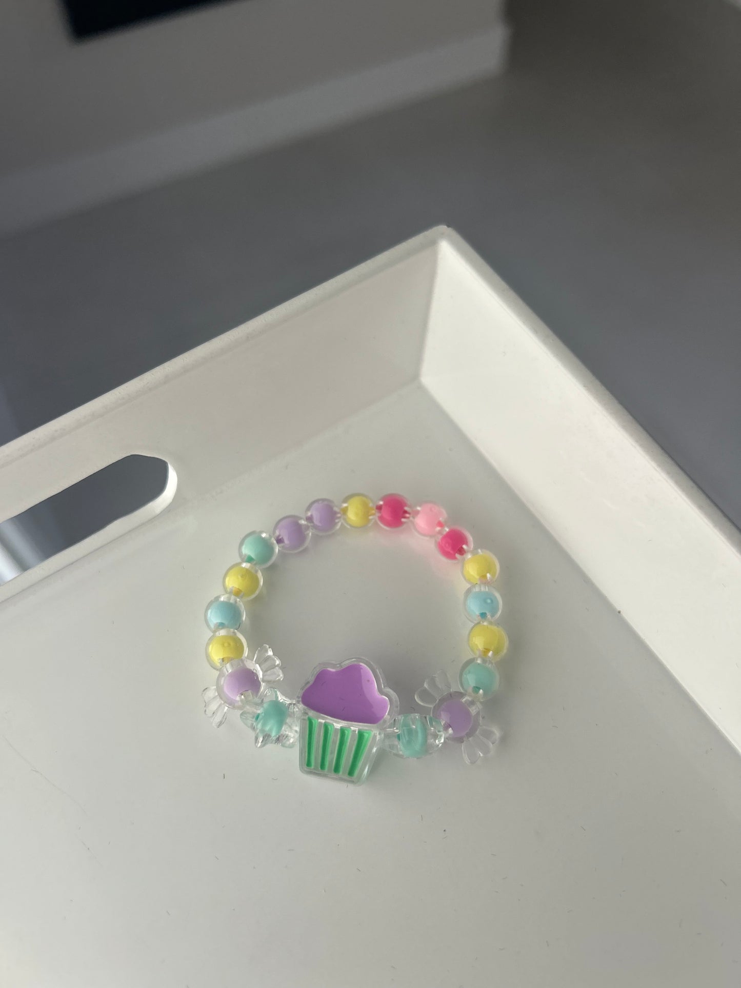Colorful beaded bracelet with a heart charm on a white surface