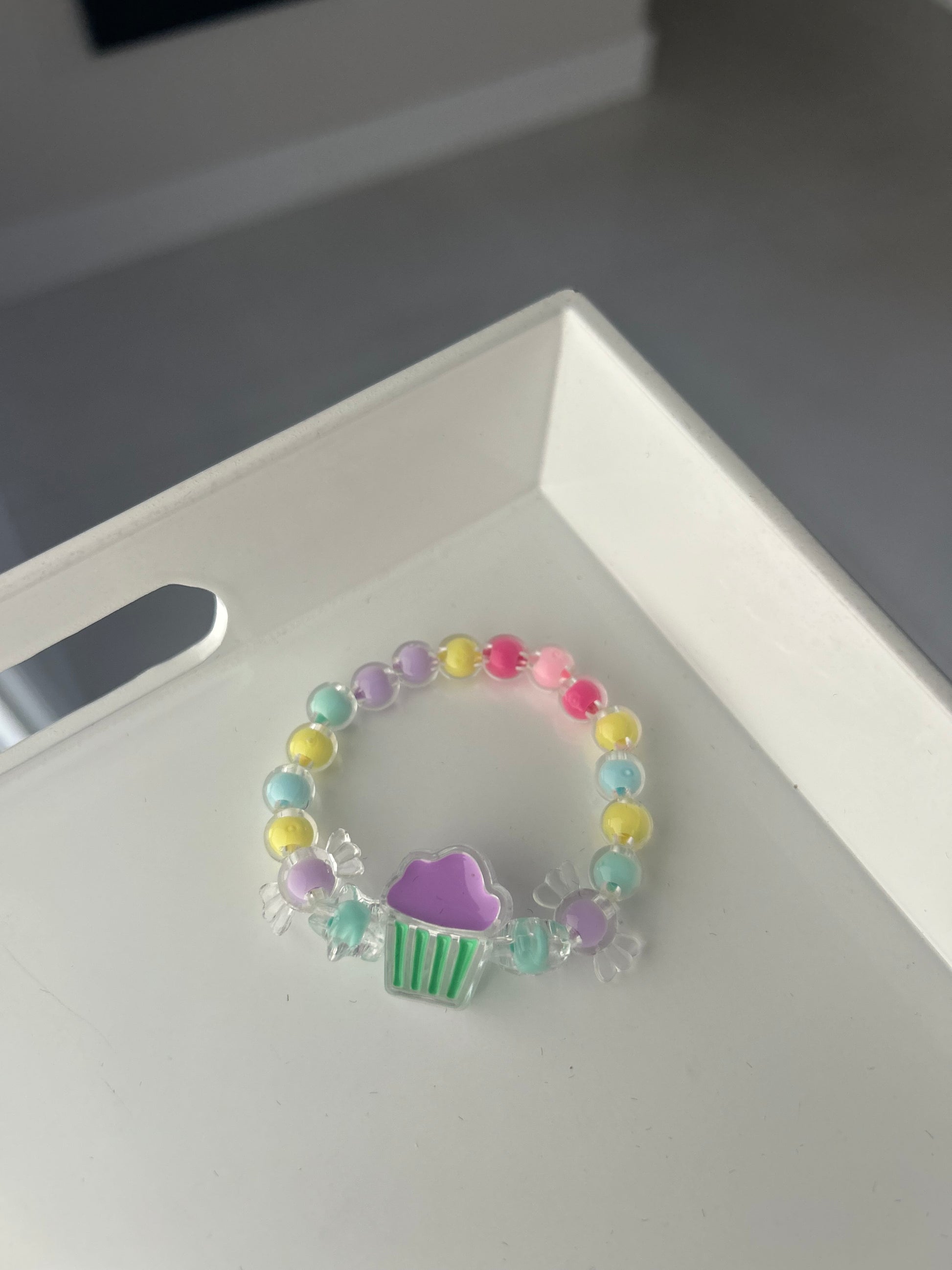 Colorful beaded bracelet with a heart charm on a white surface