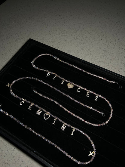 Two silver necklaces on a black card with 'Pisces' and 'Gemini’s' branding.