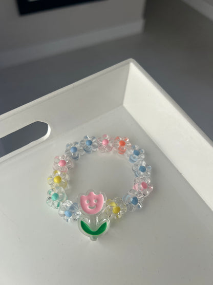 Colorful beaded bracelet with letter 'B' charm on a white surface