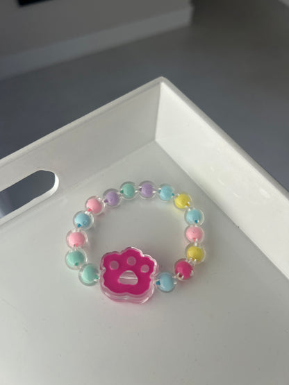 Children Colorful beaded bracelet with a pink character charm on a white surface