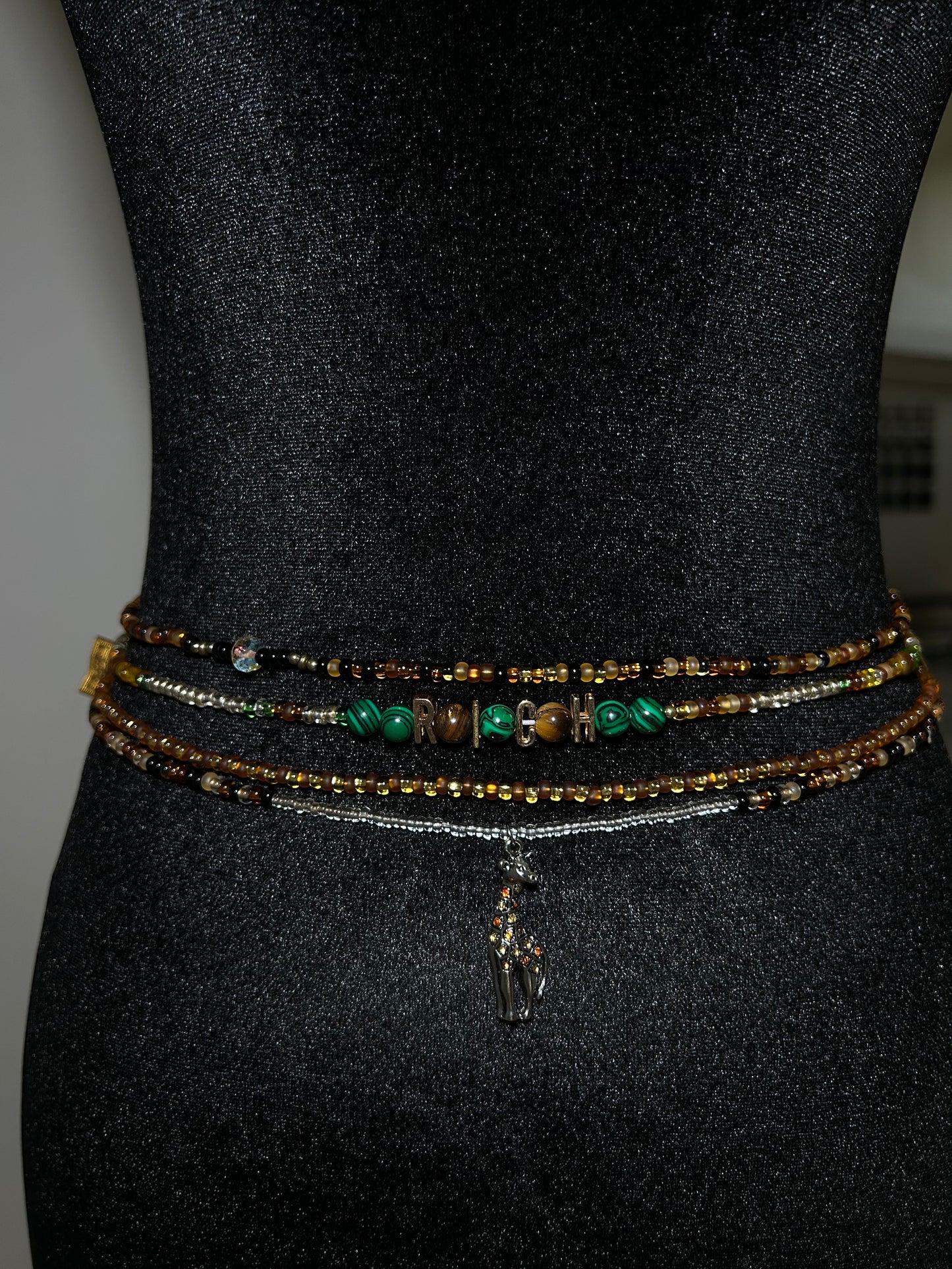Set of beaded bracelets on a black mannequin waist 