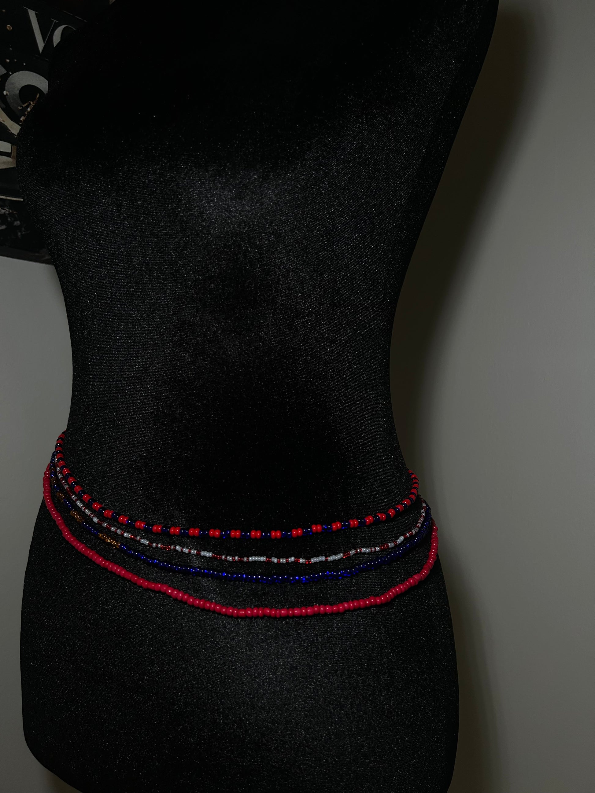 Black bow tie with red and blue stitching on a dark background