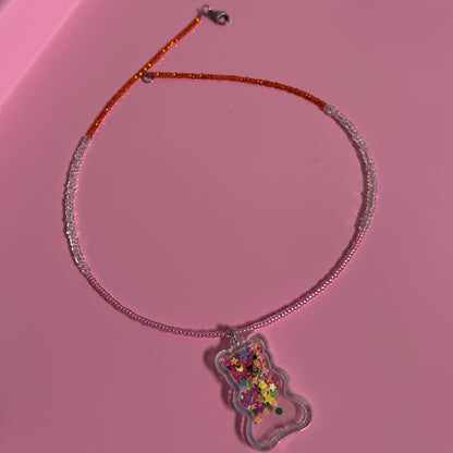 Children Necklace with a colorful charm on a pink surface