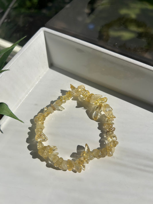 Yellow crystal bracelet on a white surface with a blurred background