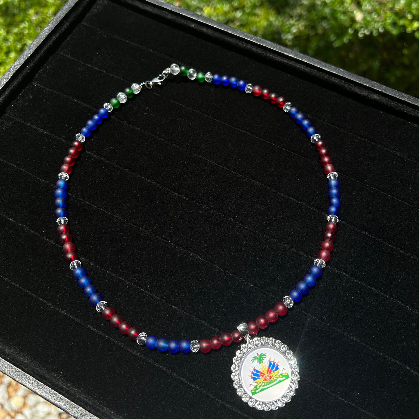 Bracelet with colorful beads and a silver charm on a black surface