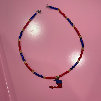 Necklace with red, blue, and gold beads on a pink background