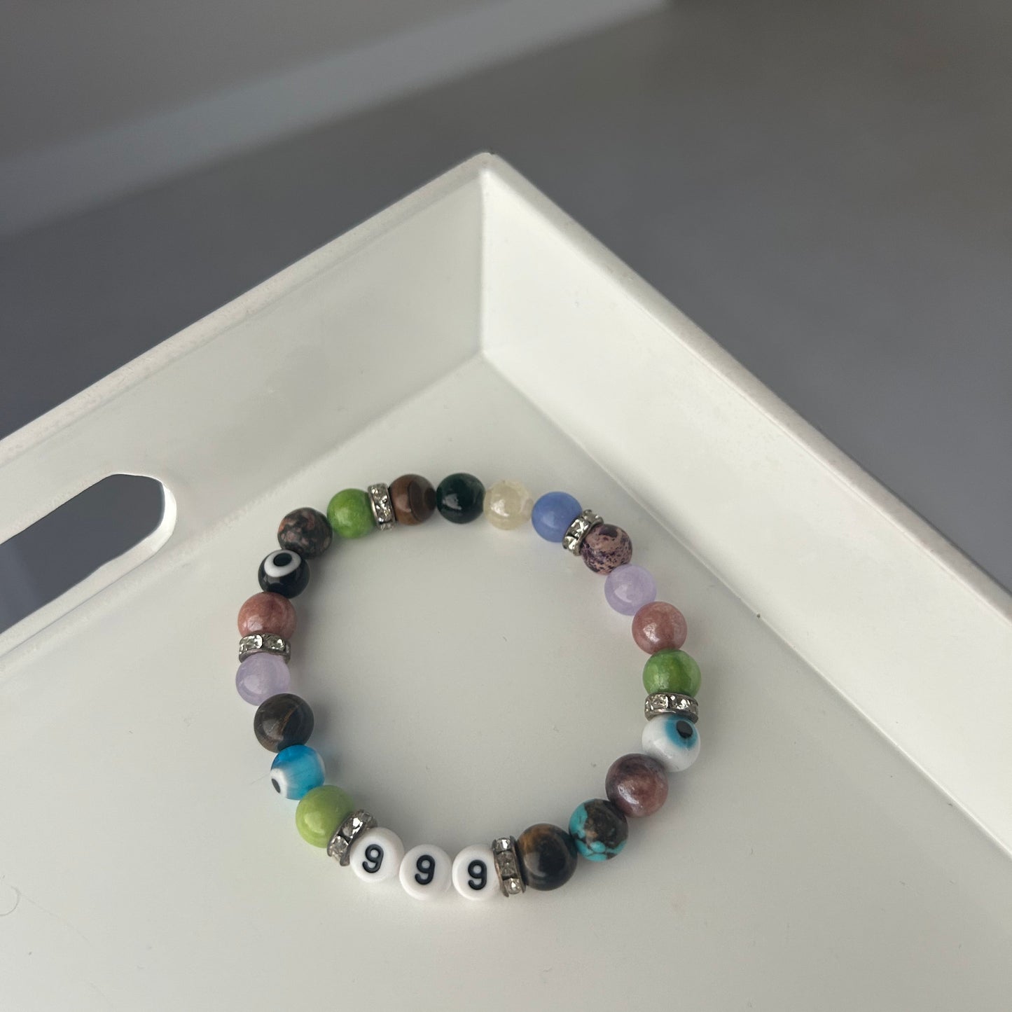 Multicolored beaded bracelet on a white surface with a blurred background