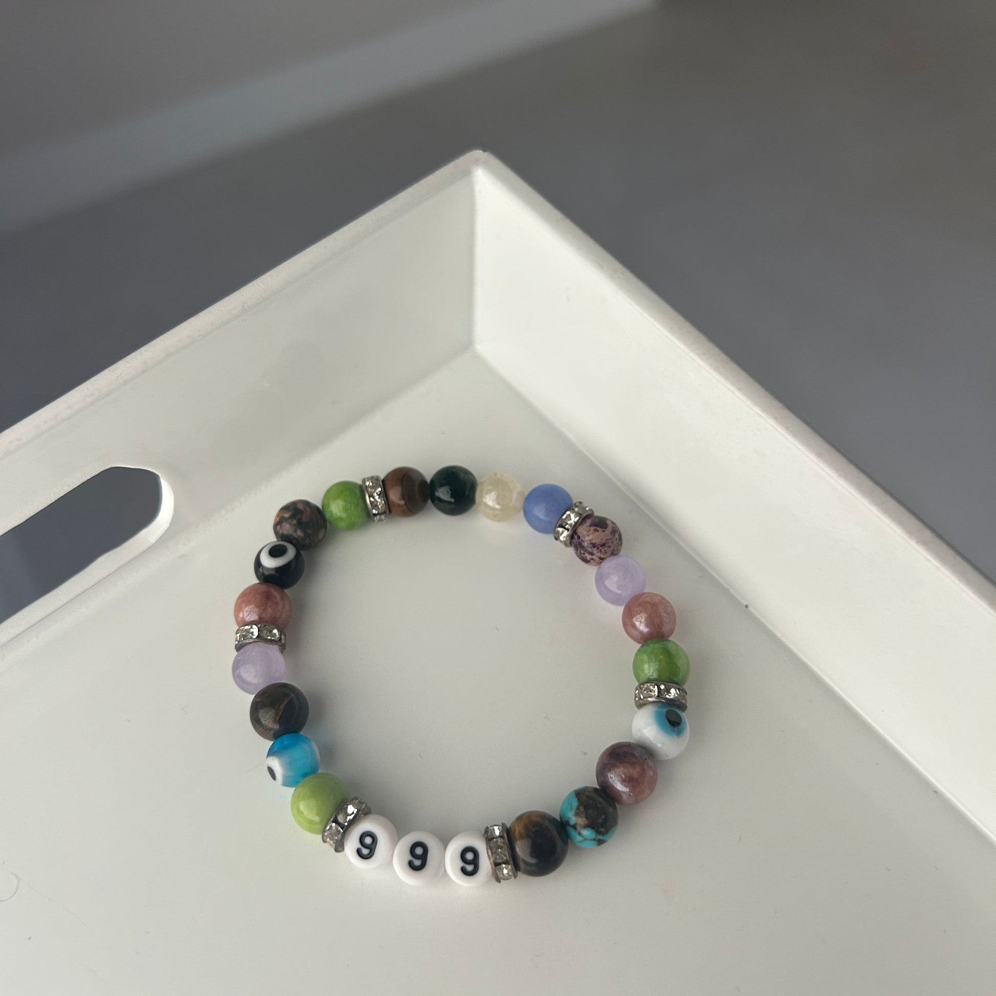 Multicolored beaded bracelet on a white surface with a blurred background
