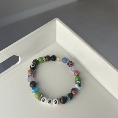 Multicolored beaded bracelet on a white surface with a blurred background