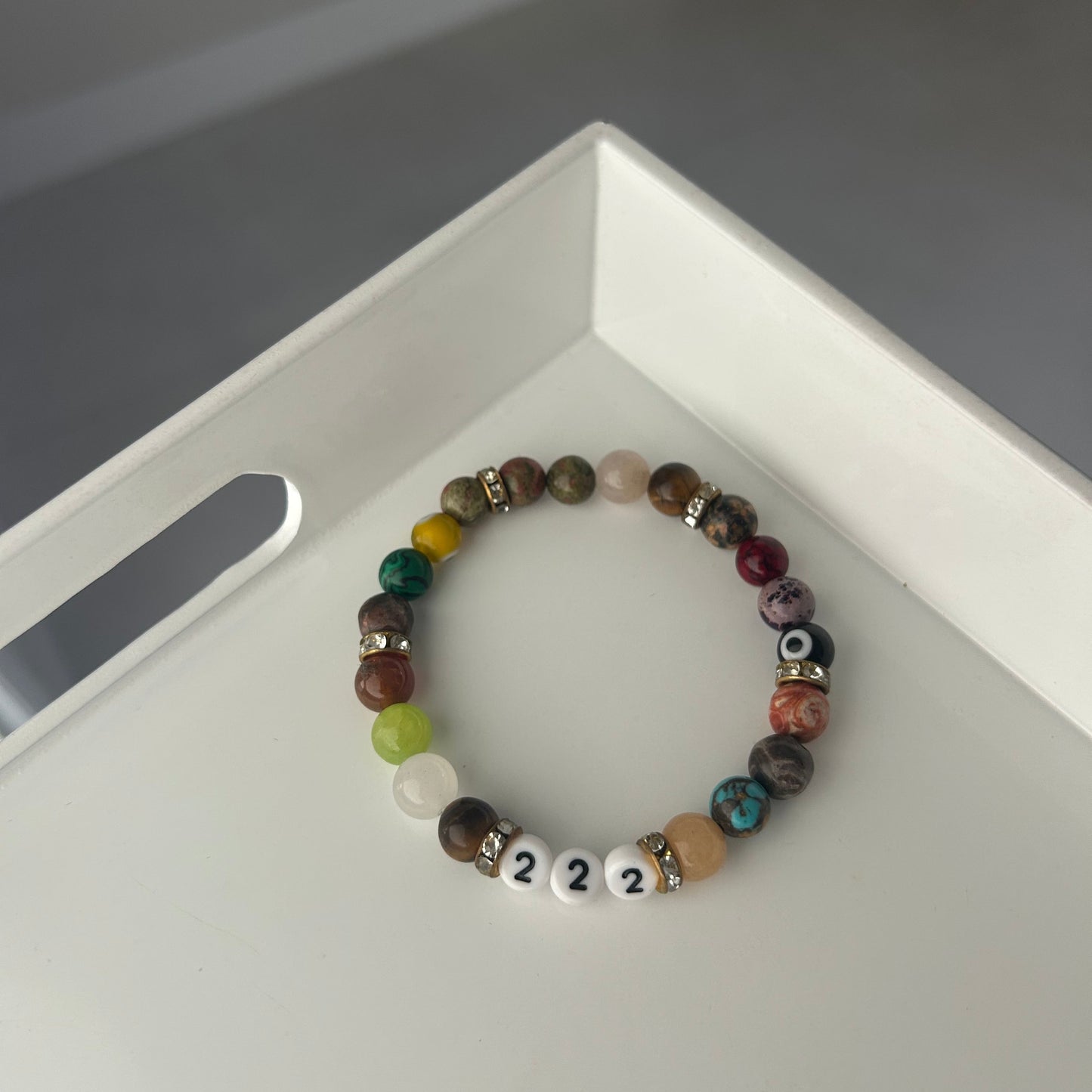 Multicolored beaded bracelet with number beads on a white surface