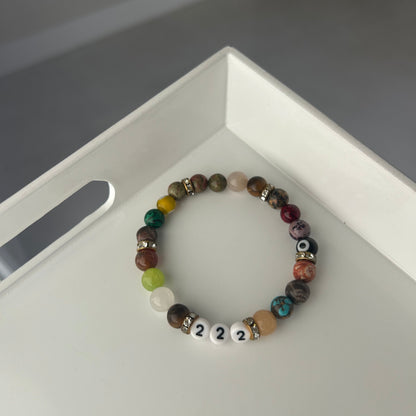 Multicolored beaded bracelet with number beads on a white surface