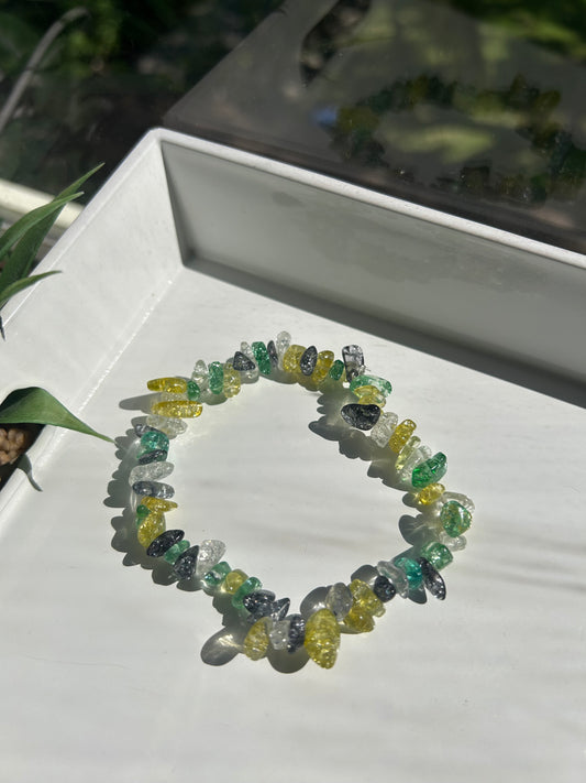 Colorful beaded bracelet on a white surface with a blurred natural background