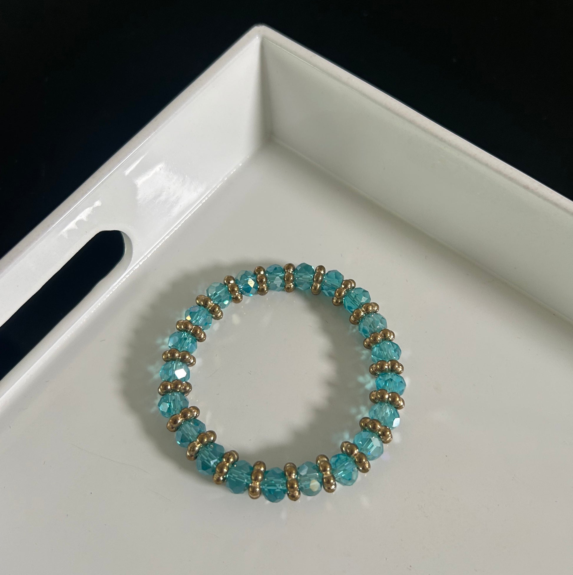 Beaded bracelet with blue and gold beads on a white surface
